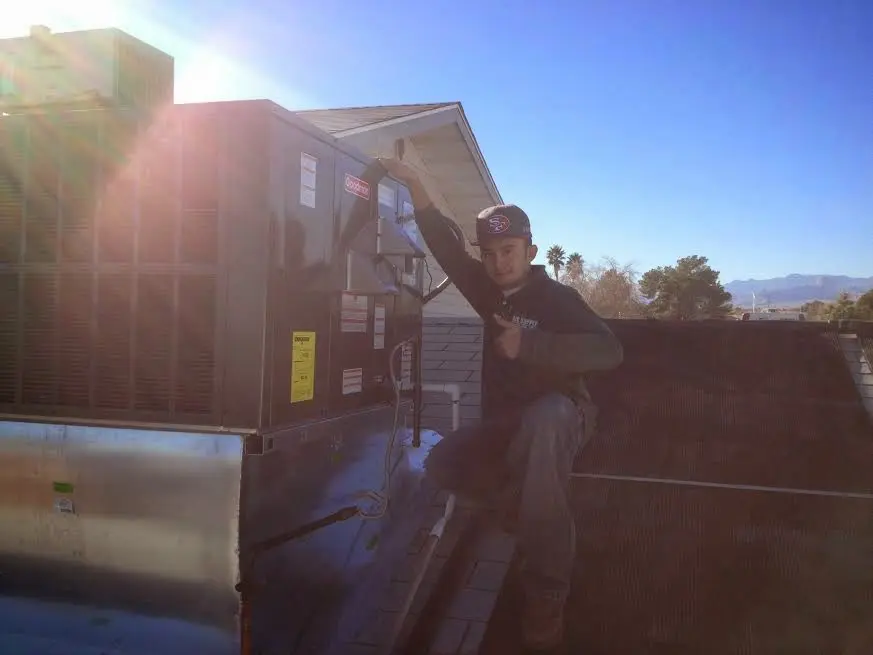 HVAC technician performing AC Tune-Up on a rooftop unit in Stone Mountain